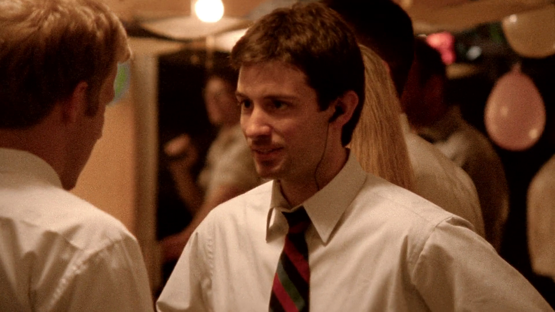 A chaotic scene at an outdoor party capturing the moment Aaron physically tackles a man wielding a shotgun.